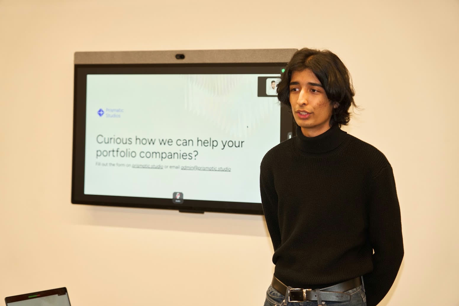Speaking at Prismatic, microphone in hand, in front of a projected slide